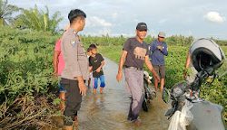 Bhabinkamtibmas Polsek Baras Datangi TKP Jalan Terputus Akibat Luapan Sungai Biai