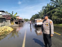 Kapolsek Pasangkayu Pantau Luapan Air Yang Sudah Sampai Ke Bahu Jalan Trans Sulawesi