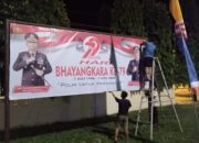 Humas Polres Pasangkayu Pasang Spanduk Hari Bhayangkara ke-79 Di Depan Mako Dan Di Titik Strategis