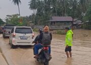 Sigap di Tengah Banjir, Bhabinkamtibmas Bambalamotu Amankan Lalu Lintas dan Sampaikan Himbauan Kamtibmas